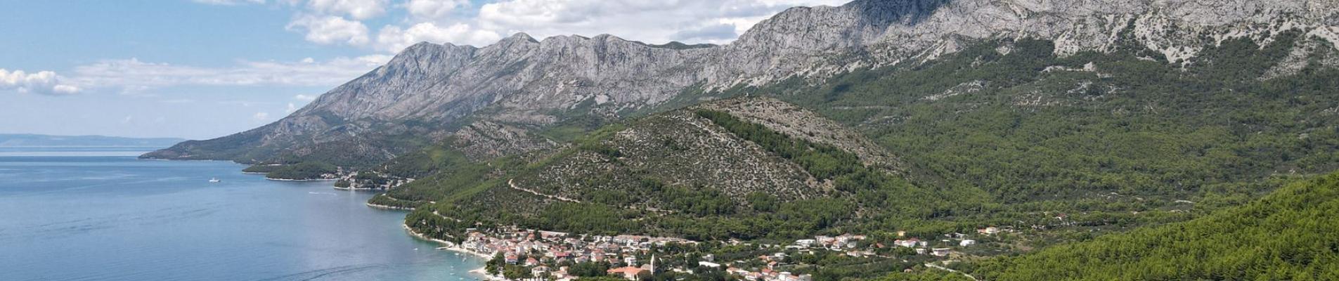 Breathtaking aerial view of Podaca's coastline with mountains, sea, and lush greenery in Croatia.