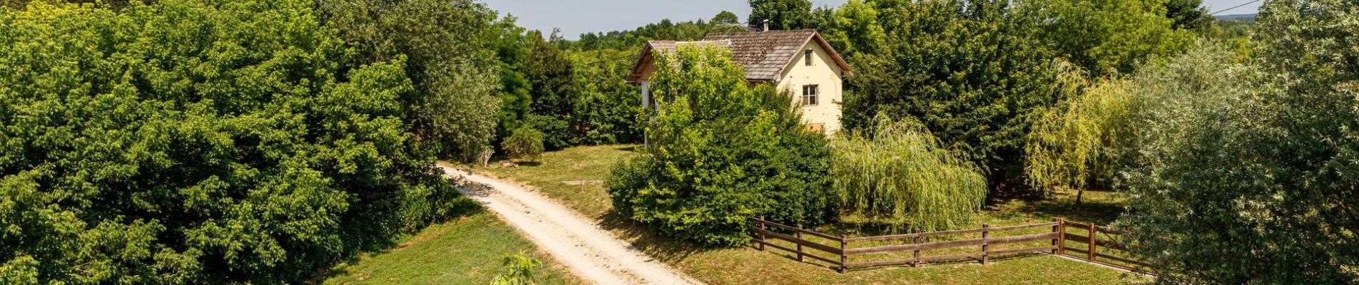 Aerial view of a scenic rural house surrounded by lush greenery in Karlovac, Croatia.