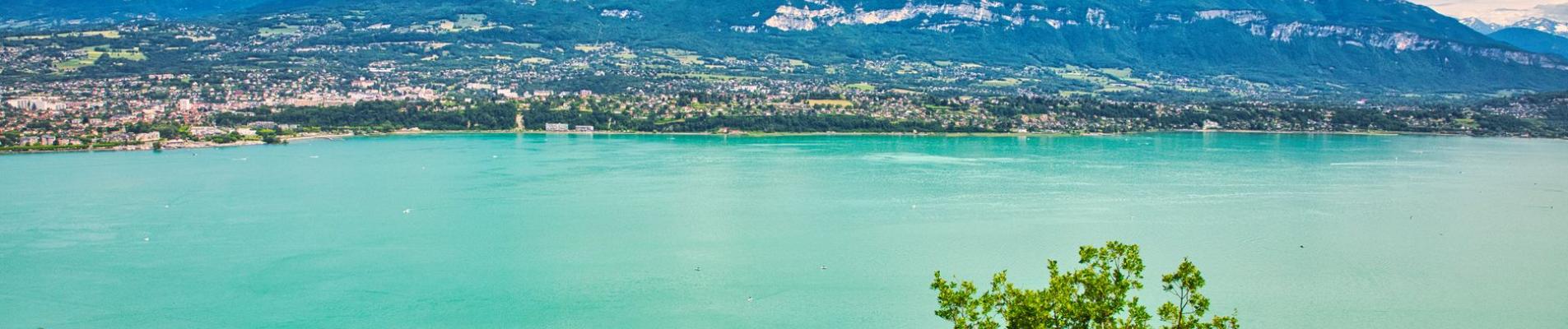 Experience the tranquil beauty of Lake Bourget surrounded by the majestic French Alps in Auvergne-Rhône-Alpes, France.