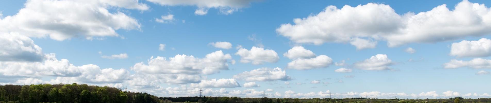 Idyllic spring scene of farmland with fields and clouds in Lauenburg, Germany.