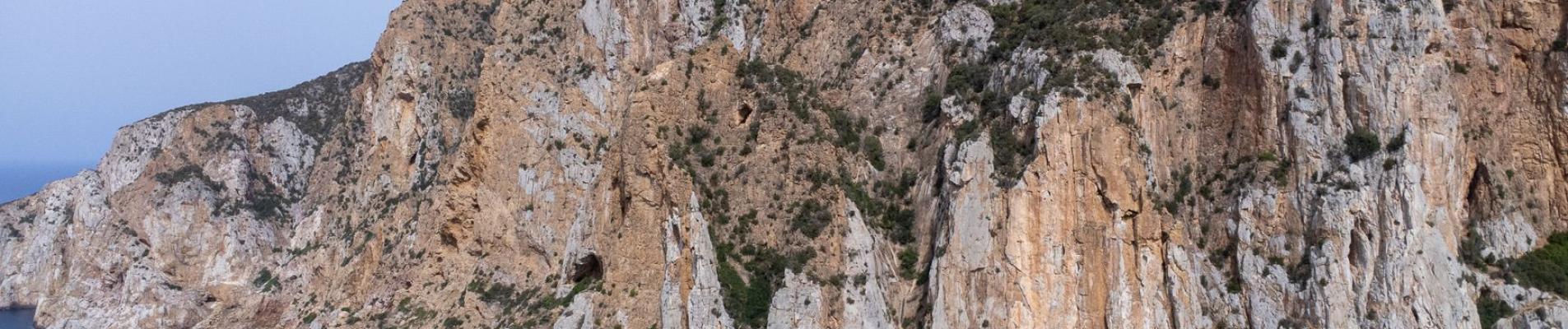 Stunning aerial view of the rugged coastal cliffs along the Mediterranean Sea in Sardinia, Italy.