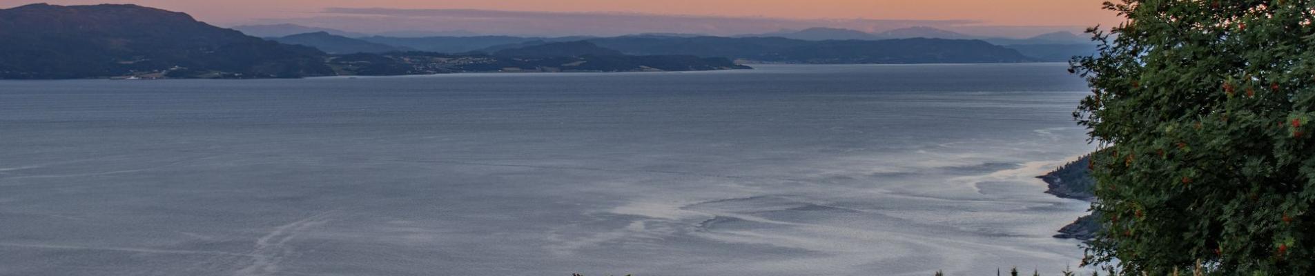 Beautiful sunset view over the calm waters and coastline of Trøndelag, Norway.