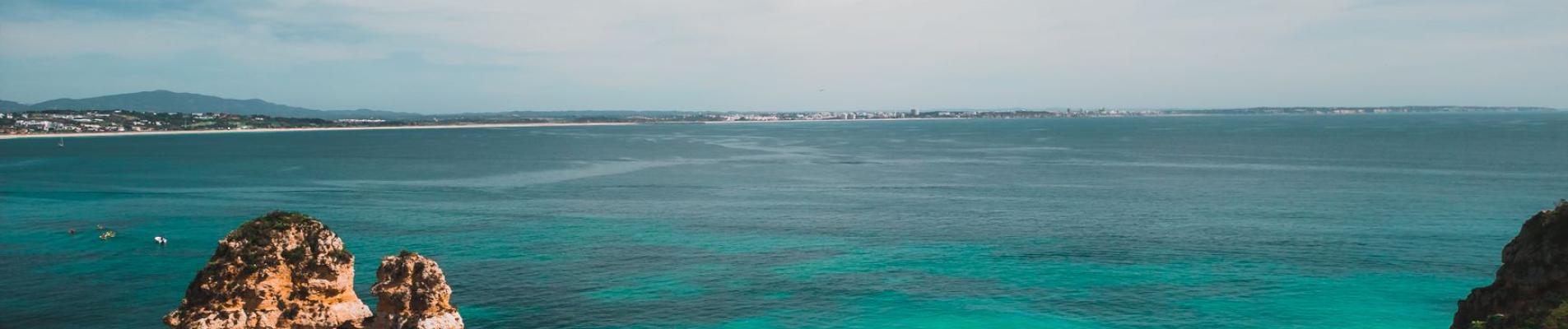 Arial view of Lagos' stunning coast with rock formations, clear sea, and lush landscape.