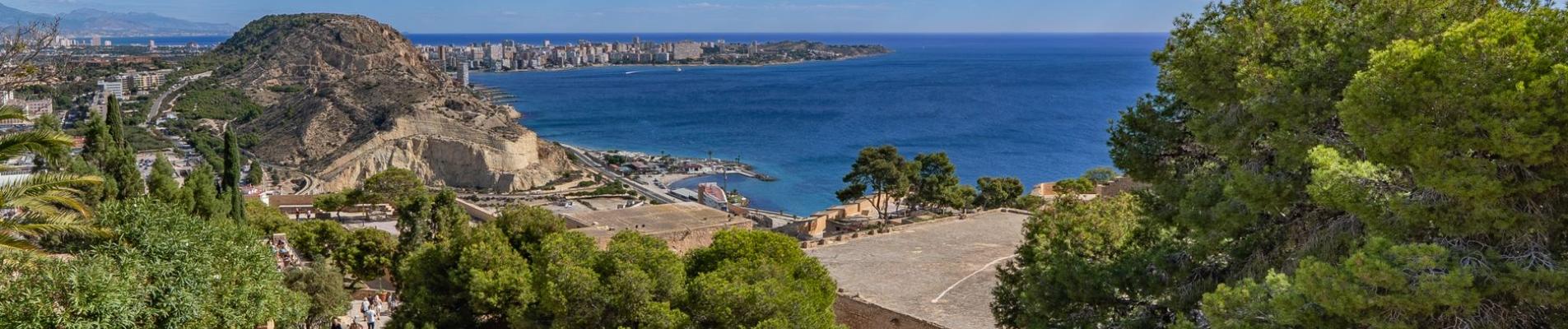 Stunning ocean and cityscape view from Alicante, Spain under a bright blue sky.