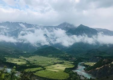 Stunning view of lush valleys and cloud-covered mountains in Përmet, Albania.