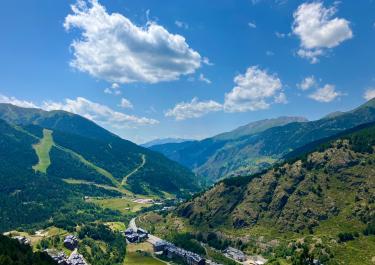 Beautiful view of Soldeu in Andorra, showcasing lush valleys and majestic mountains under a clear sky.