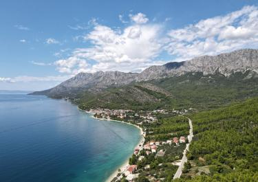 Breathtaking aerial view of Podaca's coastline with mountains, sea, and lush greenery in Croatia.