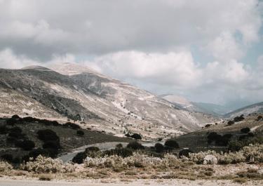 A tranquil mountain scene with greenery and clouds, perfect for outdoor and nature themes.