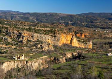 Picturesque view of rugged cliffs and greenery in a mountain landscape during daytime.