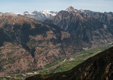 Panoramic view of Anniviers valley in Switzerland with majestic Swiss Alps under a clear blue sky.